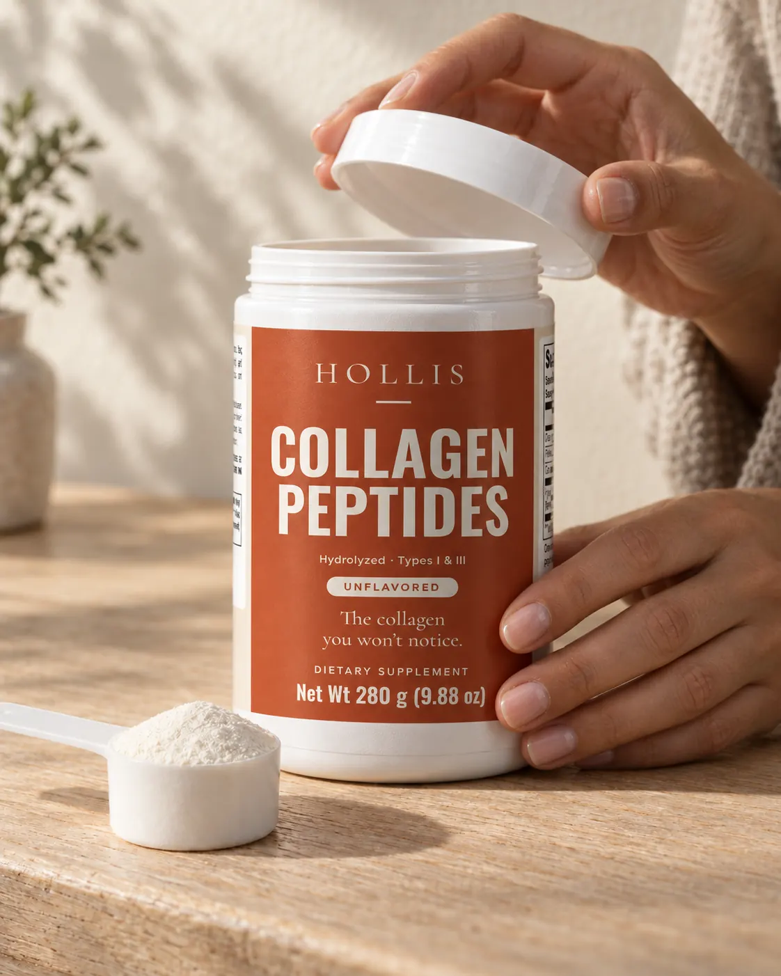 A hand lifting the lid off the Hollis container on a sunlit counter